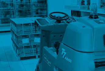 Robotik-Scheuersaugmaschine, die sich um eine Palette in einem Laden bewegt.